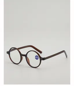Detail of +2.00 reading glasses lens with anti-blue light label and amber round frame