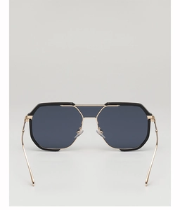 Close-up of black polygonal sunglasses with gold bridge and dark grey lenses