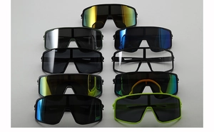Flat lay of nine pairs of cycling sunglasses in various lens colors and frame finishes