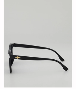 Detailed side view of black thick-frame sunglasses with gold cross metal decor