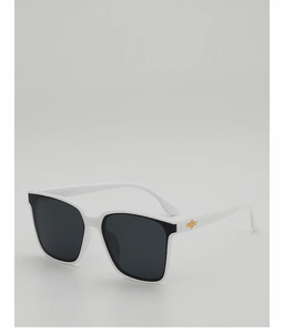 Detail view of white square sunglasses with a gold metal cross star hinge and dark grey lenses