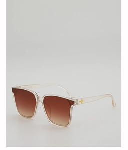 Detail of the golden cross-star ornament on the translucent brown square frame sunglasses