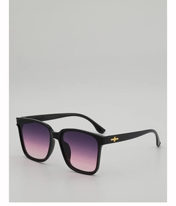 Detail of black square sunglasses with gradient purple lenses and gold star emblem