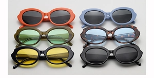 Flat lay of oval lip-shaped sunglasses in vibrant colors like orange and blue