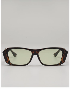 Detailed view of square tortoiseshell sunglasses with faceted edges and light green lenses