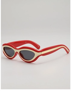 Détail de lunettes de soleil œil de chat rouges avec bordure dorée et verres
