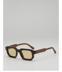 Détail de lunettes de soleil marron transparent avec branches larges et specs