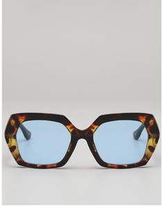 Front view of oversized tortoiseshell frames with light blue lenses and metal logo detail
