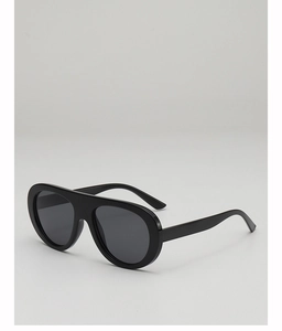 Detail showing oversized black frame sunglasses with dark lenses and integrated nose bridge