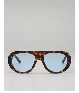 Close-up of tortoise shell frame sunglasses with light blue transparent lenses and flat top