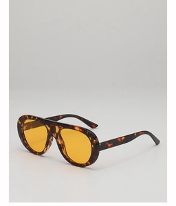 Detailed view of tortoise shell frame and amber tinted lenses on aviator sunglasses