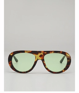 Detailed view of tortoiseshell aviator sunglasses with transparent green lenses and thick frames
