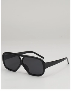 Close-up of retro double-bridge sunglasses with thick black frames and dark lenses