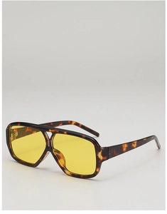 Detail of retro tortoiseshell pilot sunglasses with vibrant yellow lenses and metal hinges