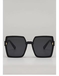 Gros plan de lunettes de soleil carrées noires avec de discrets détails en métal doré