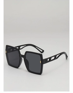 Vue latérale détaillée de lunettes de soleil carrées avec détails géométriques dorés