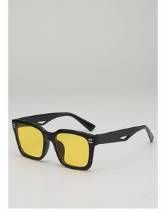 Détail de lunettes de soleil carrées noires avec verres jaunes et branches ajourées