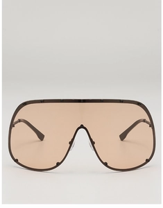 Detail of oversized shield sunglasses with light brown lens and studded dark frame