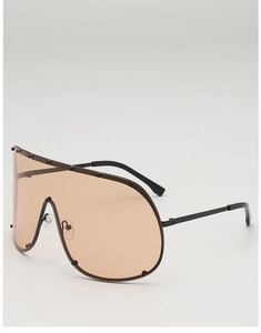 Close-up of oversized tea-tinted shield sunglasses with black frame and decorative rivets