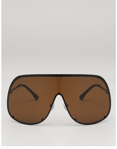 Detail of oversized shield sunglasses with brown lenses and black rivet studs on frame