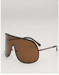 Macro detail of oversized brown visor sunglasses with black stud accents on the upper frame