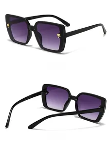 Detail of square sunglasses with gold palm tree accents and purple gradient lenses