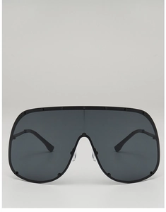 Macro detail of oversized shield sunglasses with dark lenses and round stud frame rivets