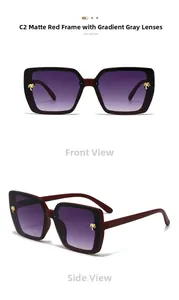 Macro detail of square matte red frames with gradient lenses and golden palm tree accents