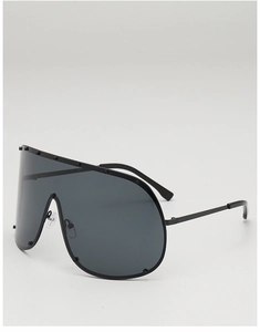 Close-up of oversized shield sunglasses with industrial rivet studs and black metal frame