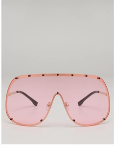 Detail of oversized pink shield sunglasses with black rivets and metallic temples