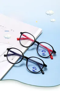 Close-up of children's blue light blocking glasses in black and red frames on a desk