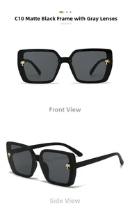 Detail of matte black square sunglasses with gold palm tree temple accent and grey lenses