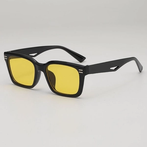 Lunettes de soleil carrées noires avec verres jaunes et branches en métal évidé