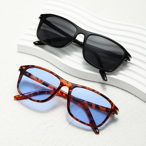 Fashionable square frame sunglasses with black and tortoise shell frames on a wavy stand