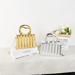 Detail of gold and silver metallic evening bags with pleated texture and bold handles