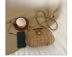 Detailed top view of a woven straw crossbody bag with leather clasp on a blazer