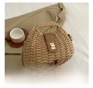 Detail of woven straw bag texture featuring brown leather strap and metal twist lock