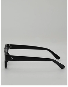 Close-up of black acetate eyeglass frames featuring iconic triple silver rivets on the temple