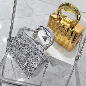 Detail of silver crinkled texture and gold pleated box bags with metal handles