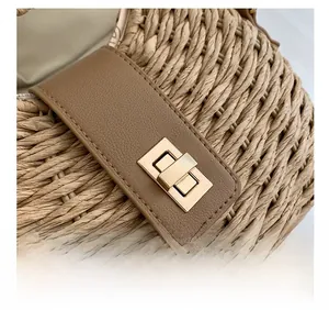 Macro shot of woven straw texture with brown leather strap and golden metal twist lock