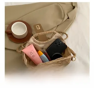 Top view of woven straw shoulder bag showing interior space with phone and makeup