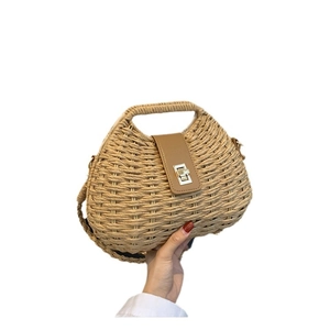 Handwoven straw shoulder bag with leather buckle and metal lock for a trendy summer look