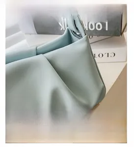 Close-up of light blue pleated leather texture and cloud-shaped folds on handbag
