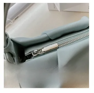 Detail shot of smooth silver zipper hardware on mint green pleated leather handbag