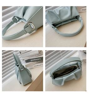 Detail showing inner capacity and silver hardware on light blue ruched cloud handbag