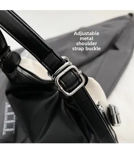 Detail of adjustable silver metal buckle on black and white shoulder bag strap