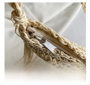 Close-up of the smooth metal zipper and intricate texture of the woven straw bag