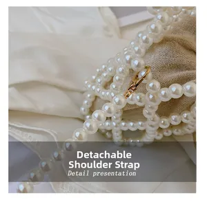 Detail of detachable white pearl strap with gold metal lobster clasp for beaded bag