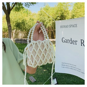 Detail of handmade pearl beaded evening bag with inner drawstring linen pouch