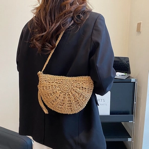 Chic woven half-moon crossbody bag with natural textures and elegant fringe detail